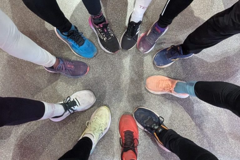 Verschiedene Sportschuhe in einem Kreis angeordnet, auf einem grauen Boden.